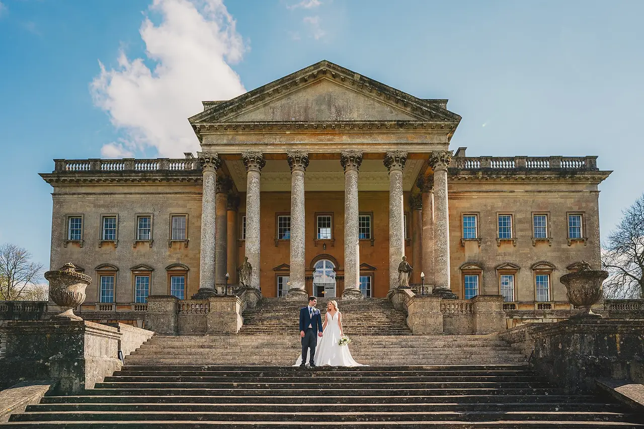 Bride and Groom holding hands standing outside grand country estate Prior Park in Bath