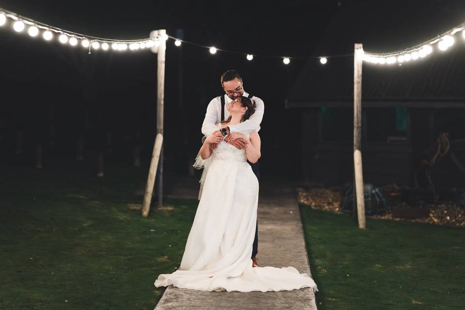 Wedding couple lit by festoons