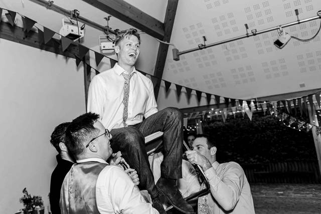 Groom being lifted on a chair