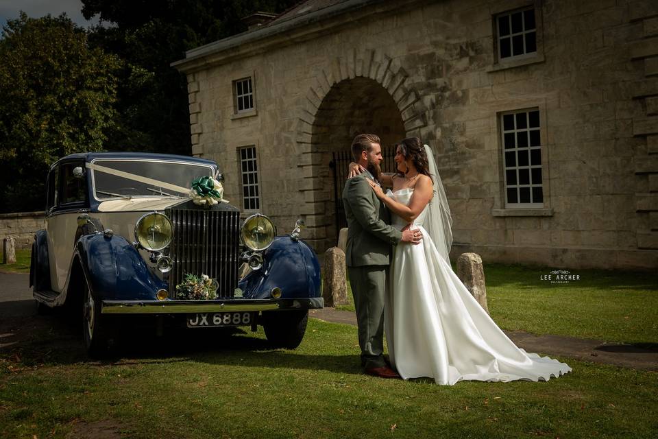 Bride and groom with car