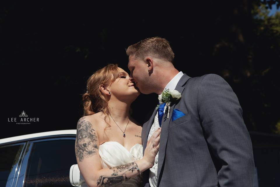 Bride and groom with car