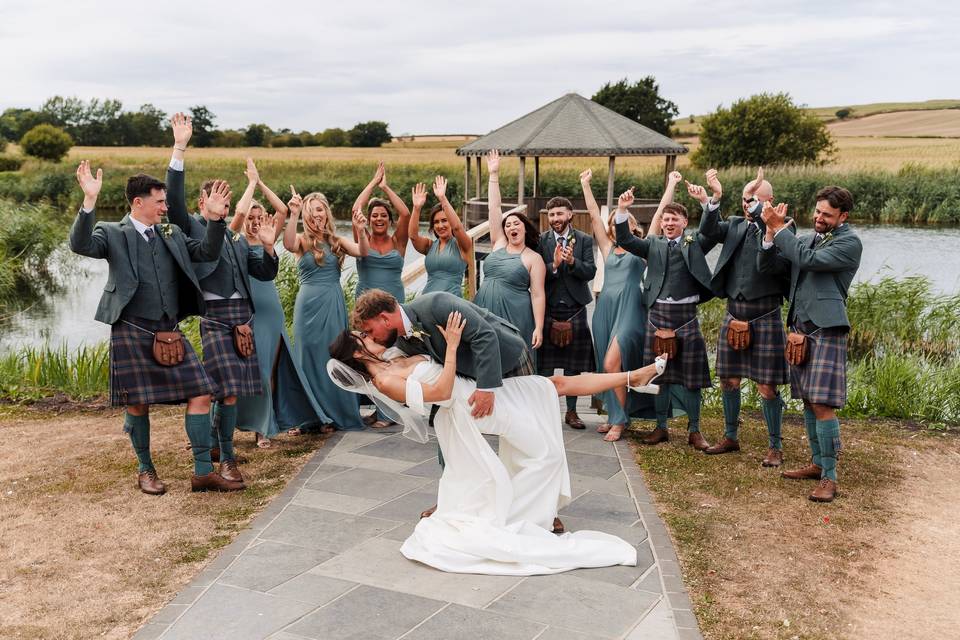 Couple kiss with bridal party