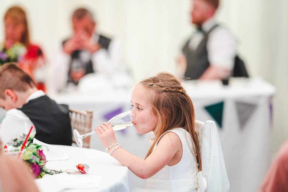 Flower girl sneaking champagne