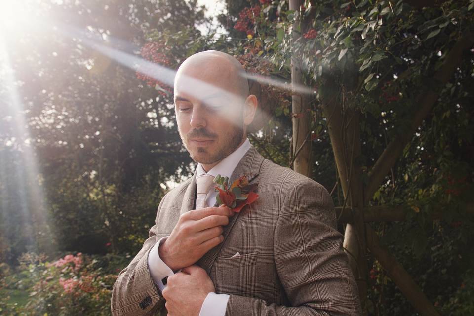 Groom adjusting flowe