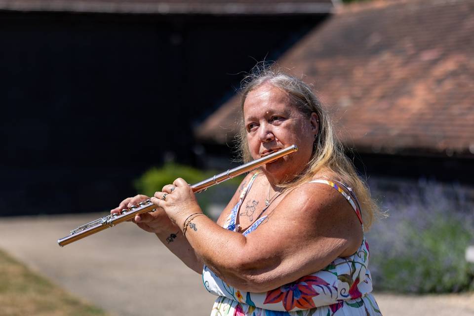 Flautist playing near lavender border