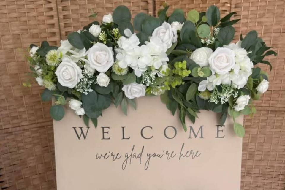 Our welcome a board and flower