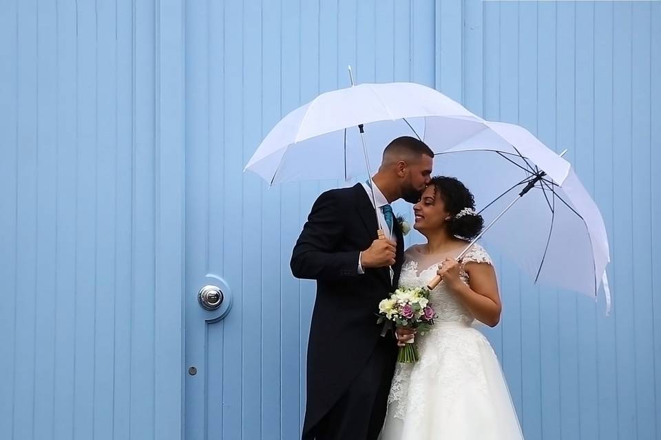 Happy couple under umbrellas