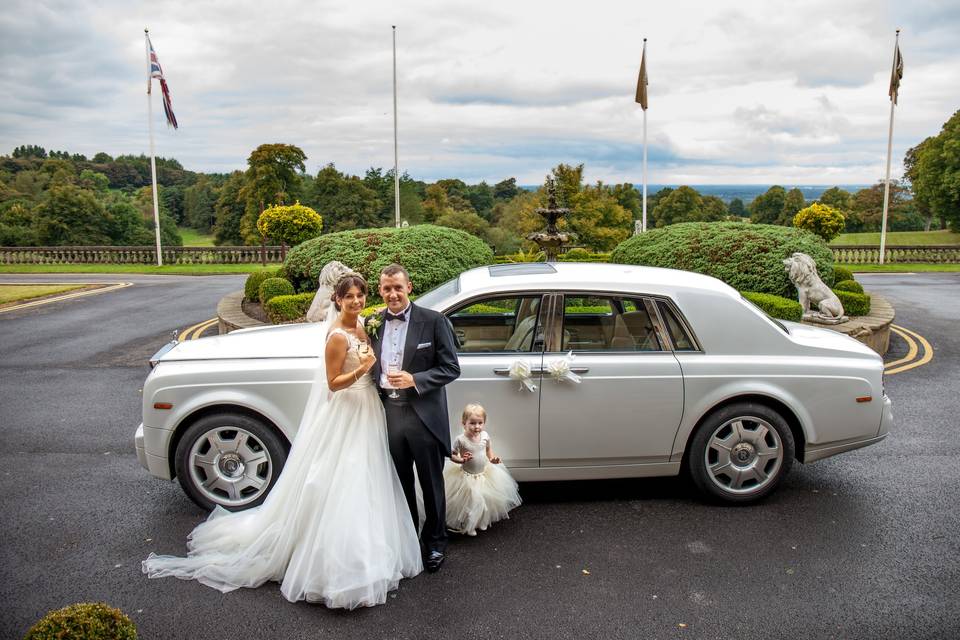 Bride and groom by the car