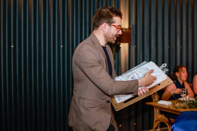 artist demonstrating caricature to wedding guests
