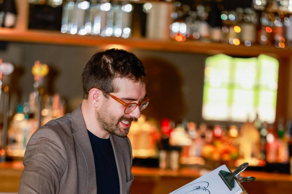 artist drawing guests near the bar