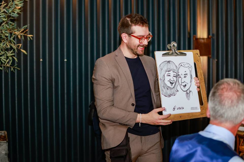 artist showing drawing to guests at table