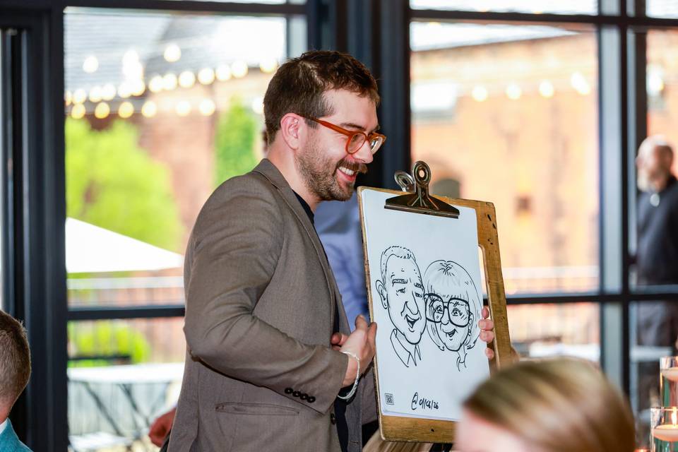 artist showing sketch to wedding guests