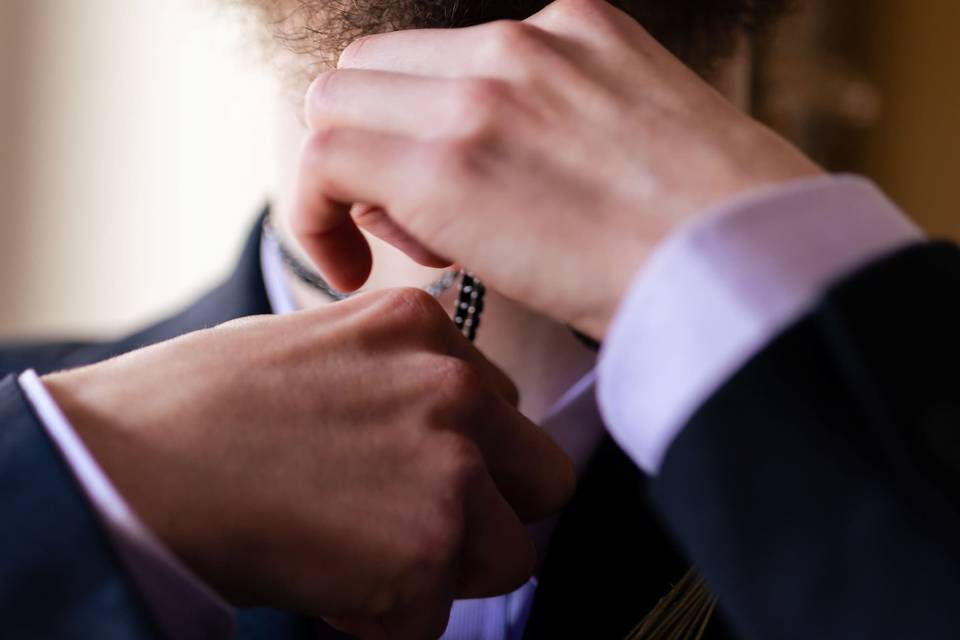 Groom adjusting necklace