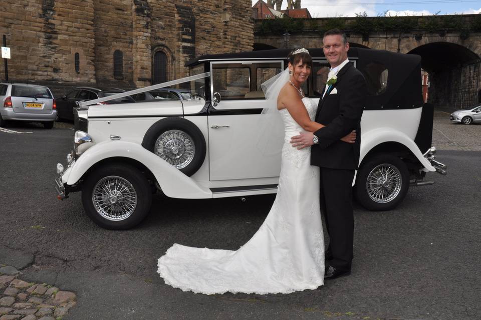 Bride and groom with the car