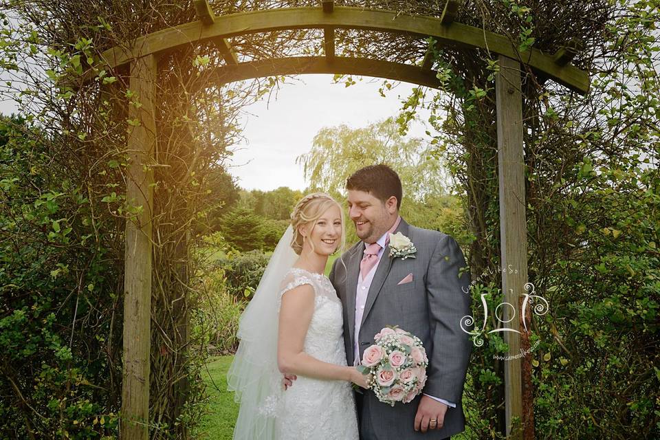 Couple pose under arch