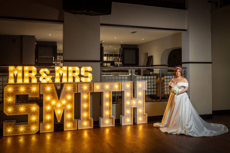 Bride next to letters on dance