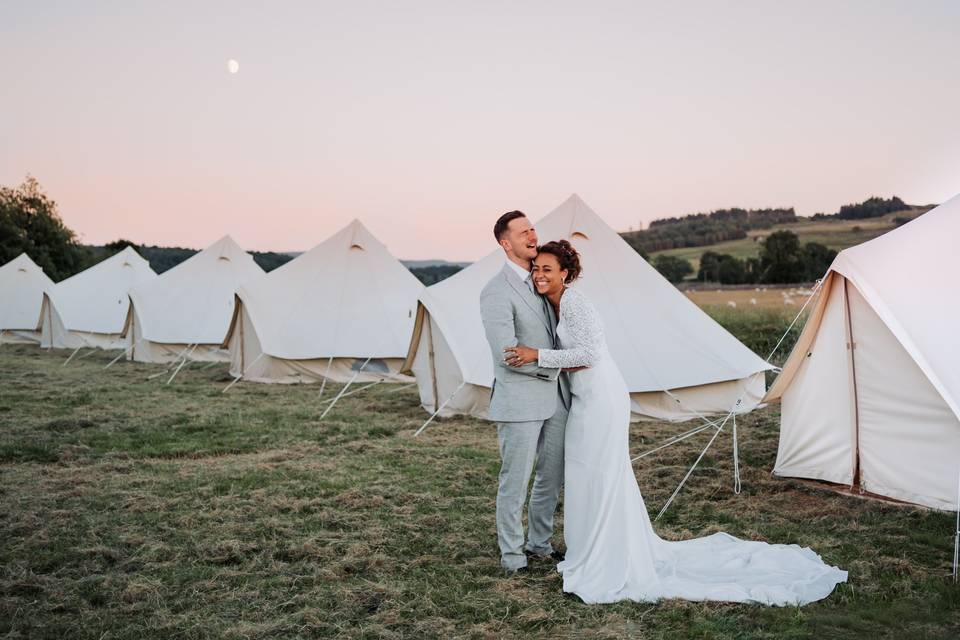 Couple by tents - Anna Wood Photography