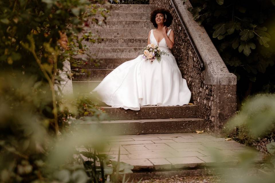 Bride sat on steps in garden