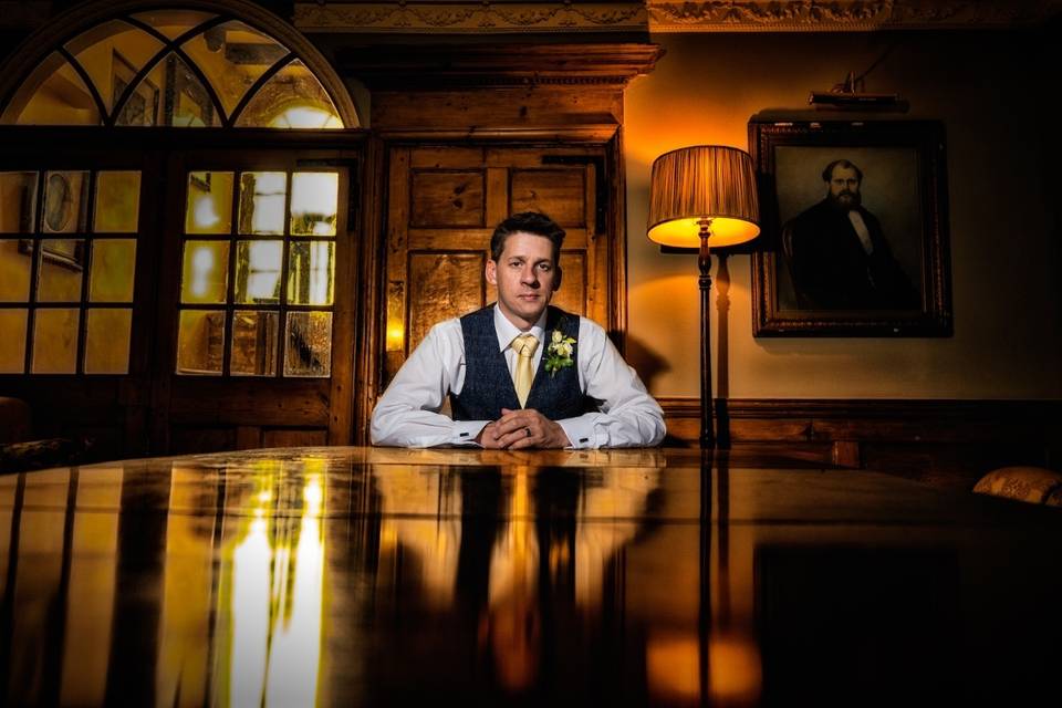 Groom seated at a table - Creating Diamonds Wedding Photography
