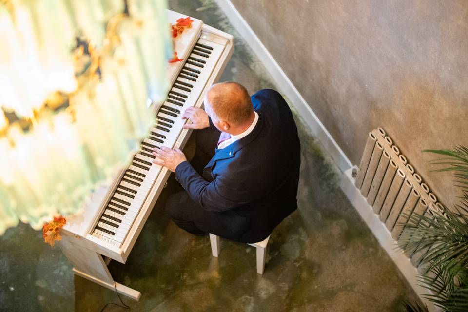 overhead shot pianist seated at upright piano