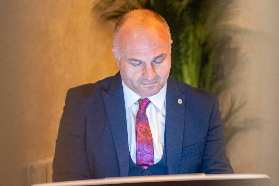 speaker at ceremony lectern with greenery