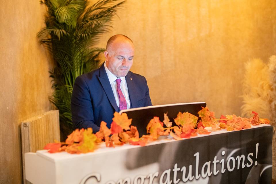 speaker at congratulations dais with palms and florals