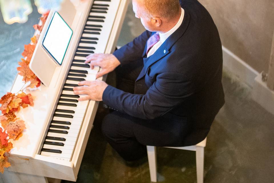 vertical full view pianist at white upright piano