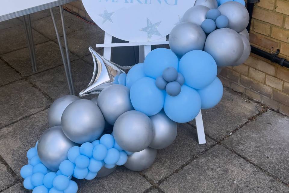 Easel, sign and balloons