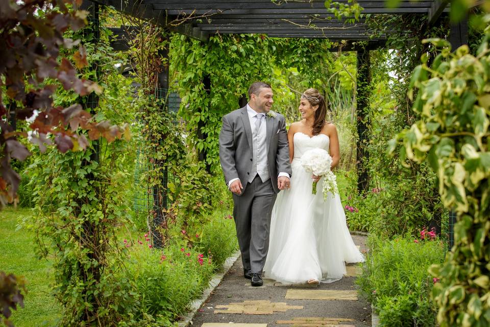 Flower filled pergola is the aisle for outdoor weddings