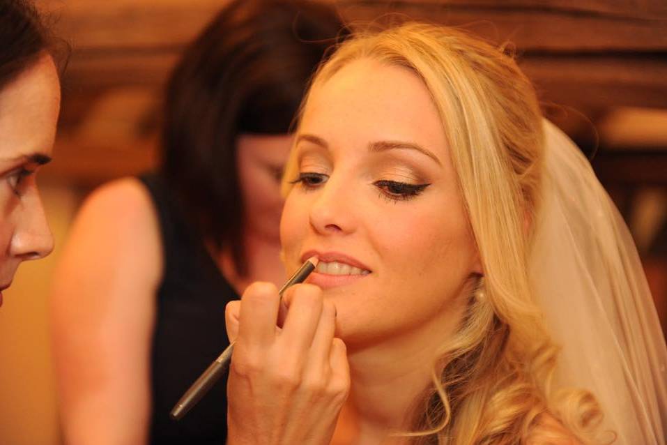 Bride having lipstick applied