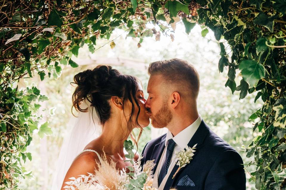 Kiss under floral arch