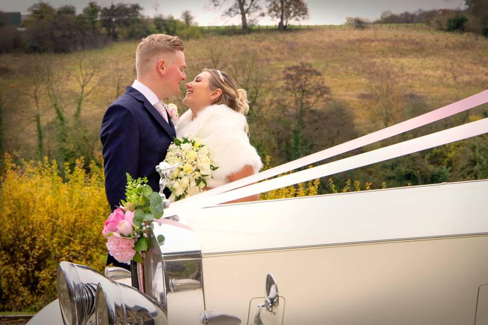 Bride and groom with car