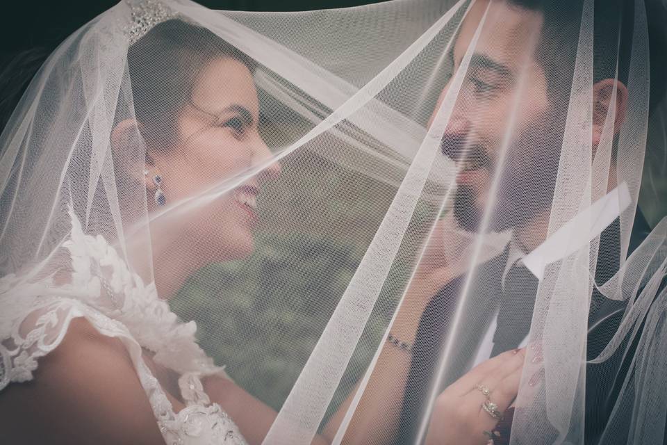 Bride and groom under veil