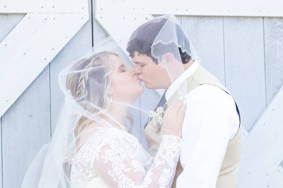 Bride and groom kiss under veil