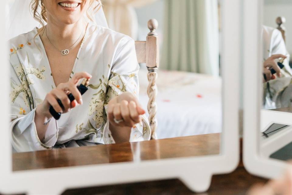 Bride applying perfume