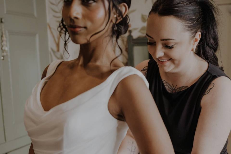 Helping bride into her dress
