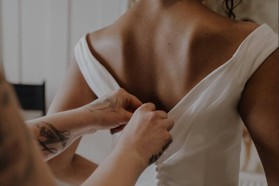 Helping bride into her dress