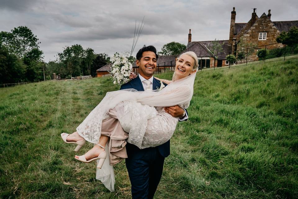 Groom carries his bride