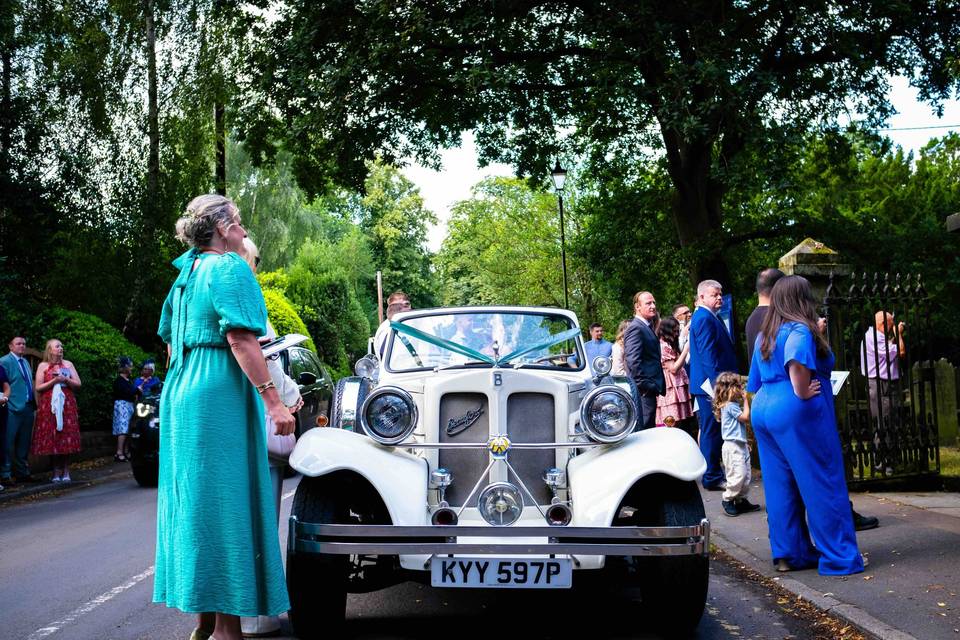 Wedding car and guests
