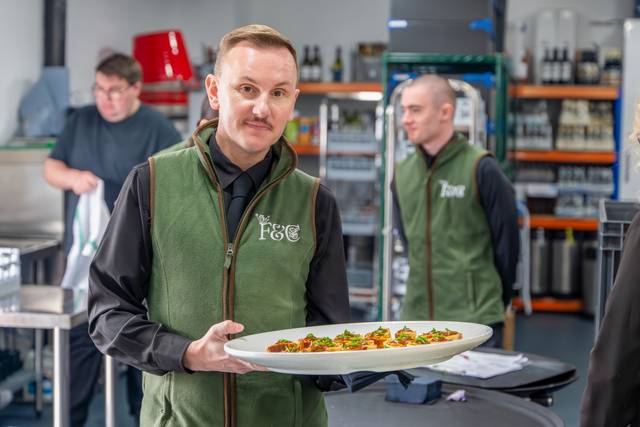 Catering staff member holding a serving tray