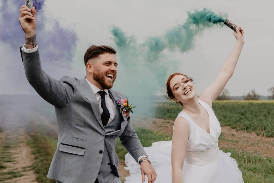 Smiling and waving colourful smoke