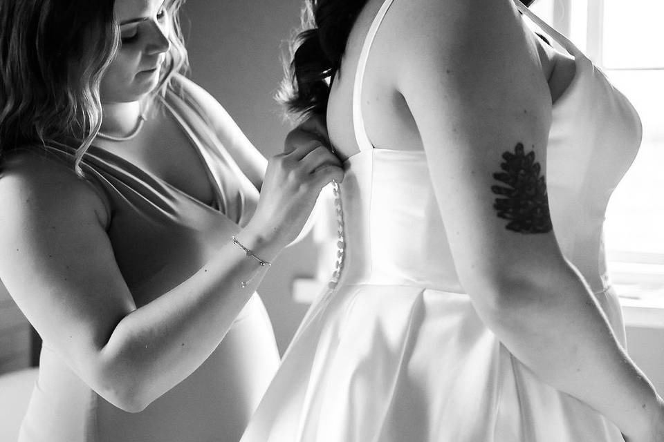 Buttoning up Bride's dress