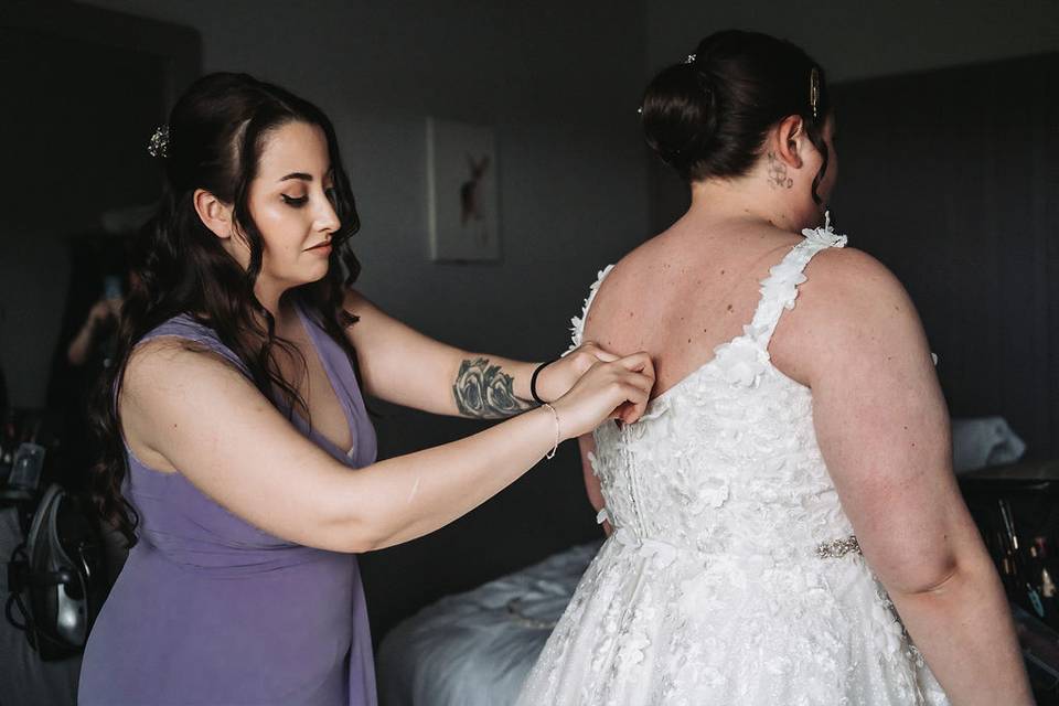 Buttoning up Bride's dress