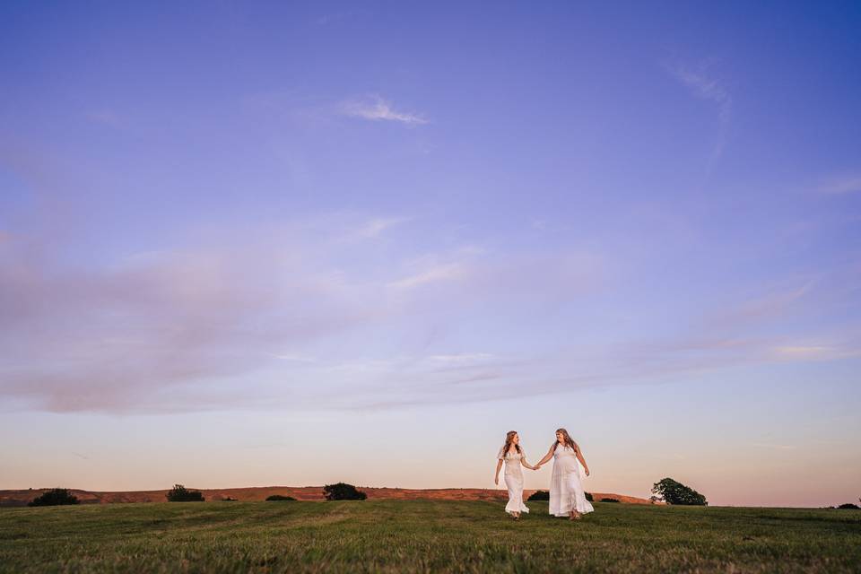 Pair holding hands at sunset