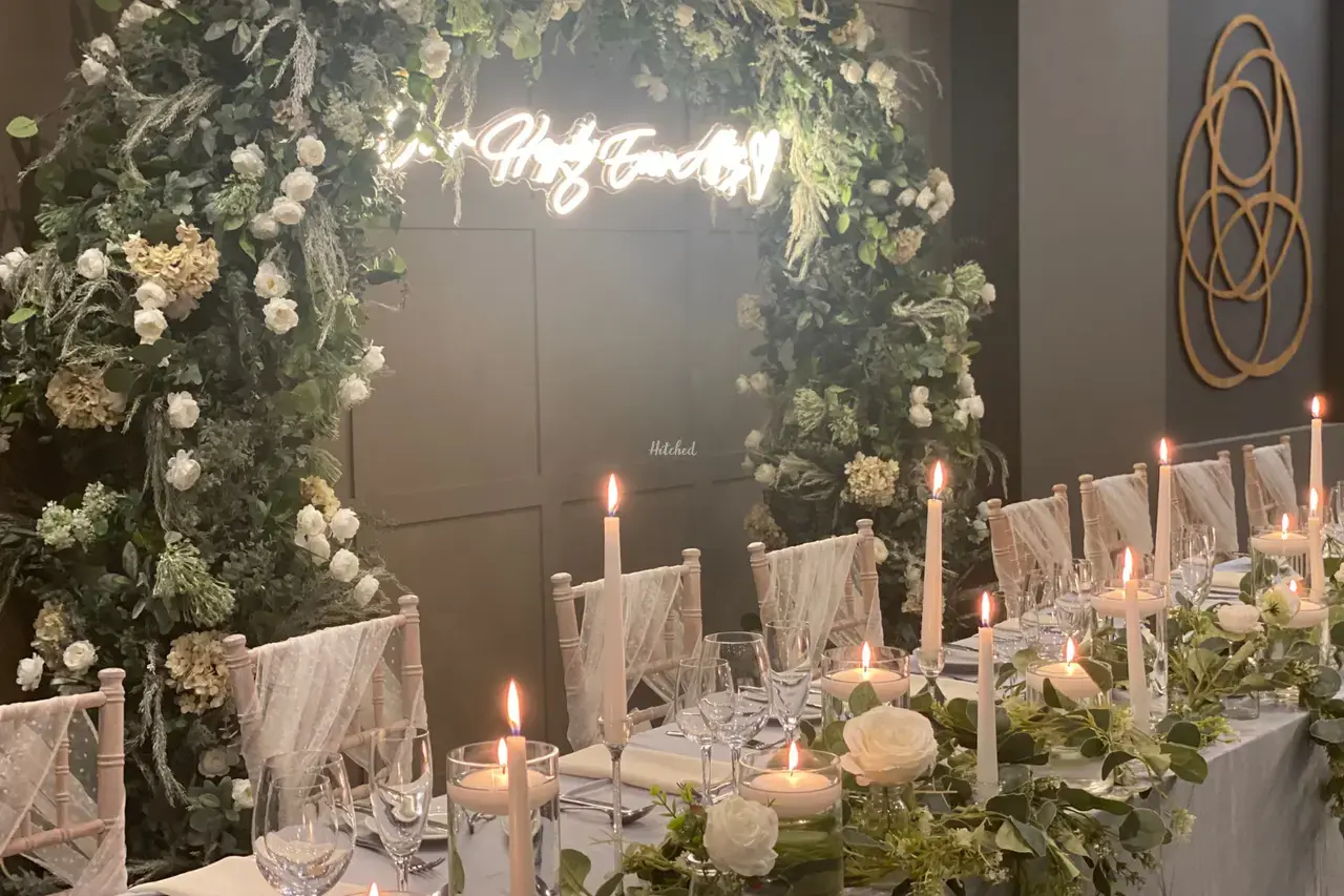 Wedding top table decorated in white with white roses and candles as centrepieces