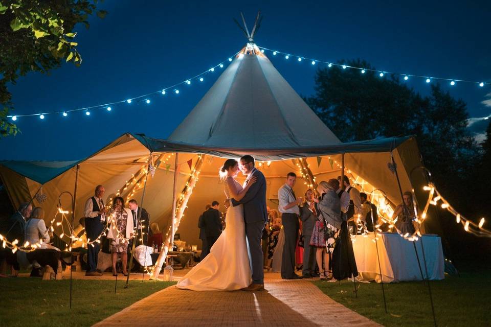 Bride and Groom by a night-time tipi