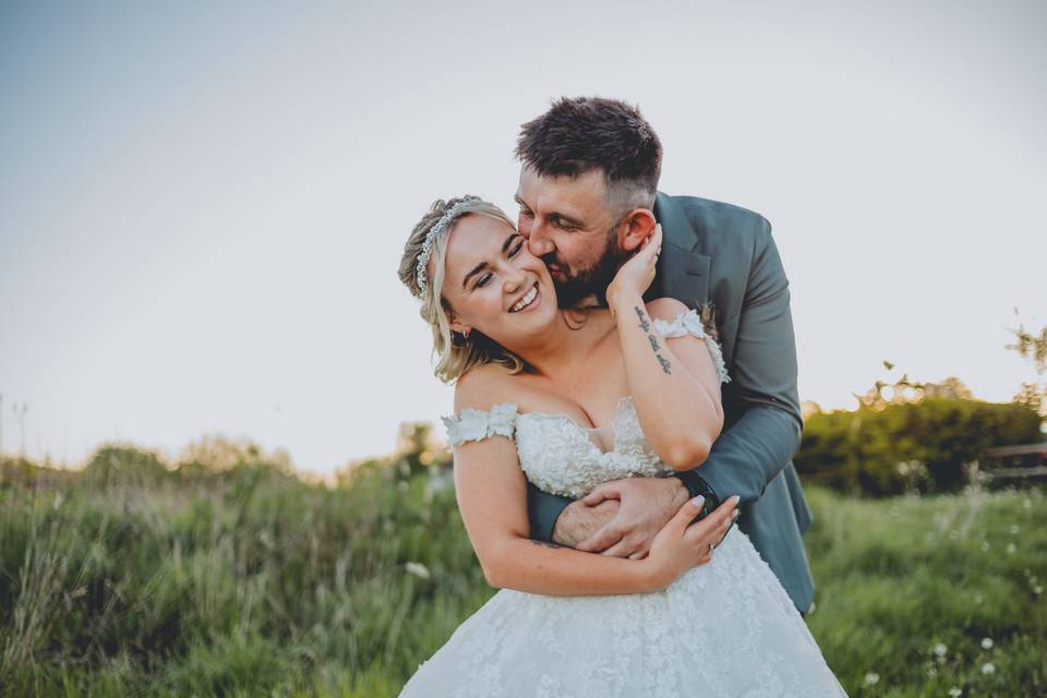 Groom kisses bride on cheek