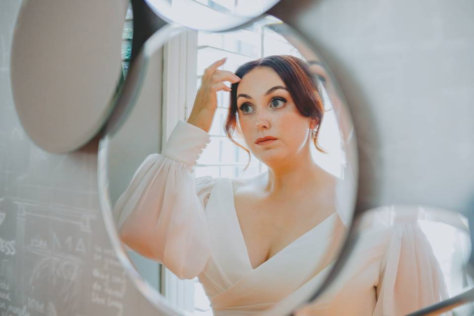 Bride checks hair in mirror
