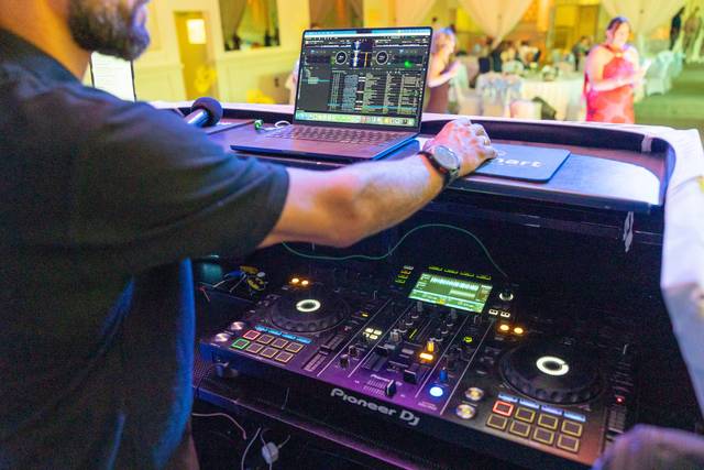 close up of dj hands adjusting knobs on digital mixer