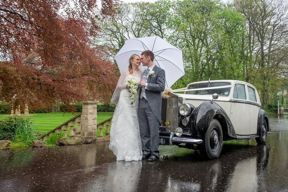 Couple standing in front of a vintage car